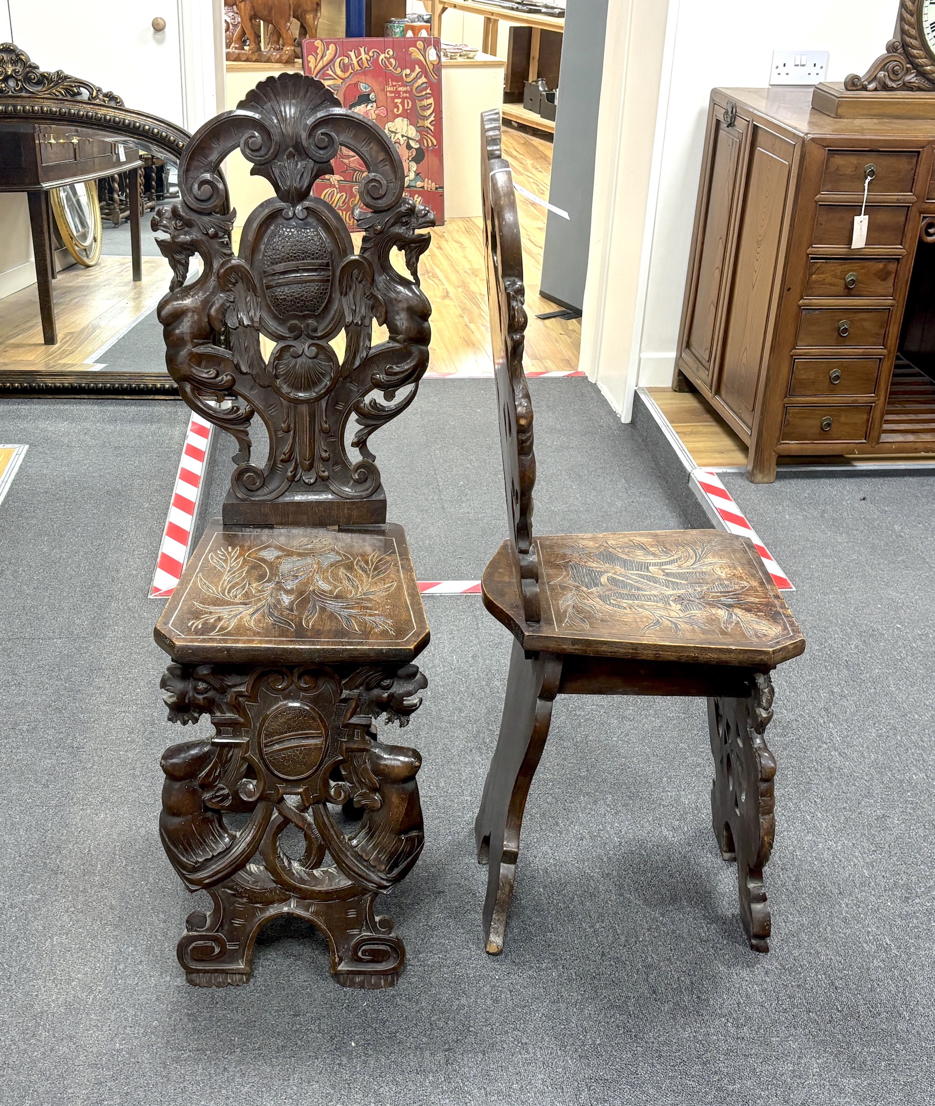 A pair of 18th century style carved walnut hall chairs, width 36cm, depth 27cm, height 106cm